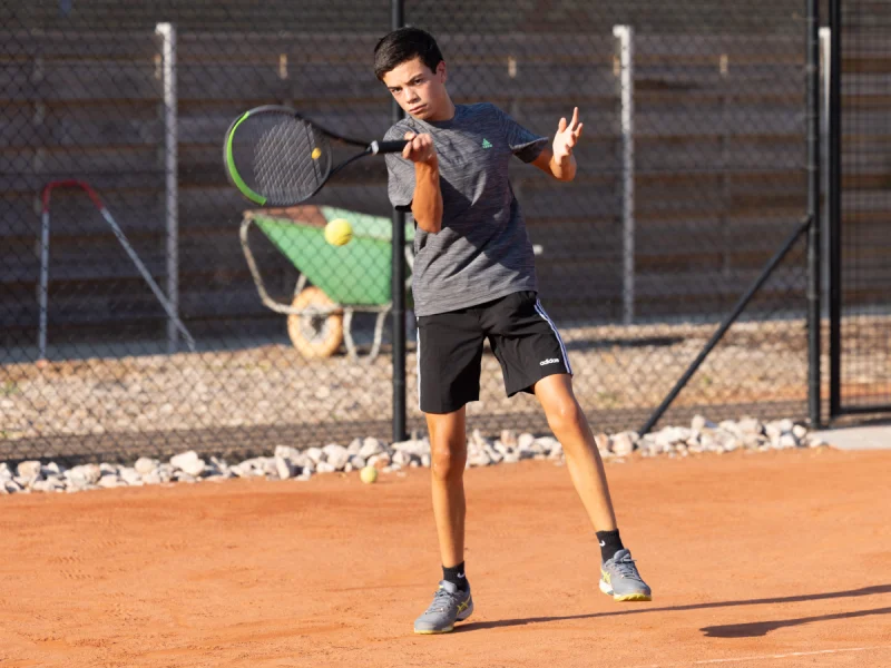 Boy Mid Tennis Match After Striking The Ball